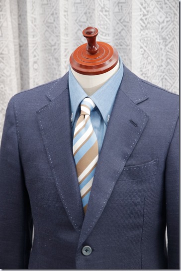 水色のデニムシャツに紺のジャケットとストライプのネクタイ