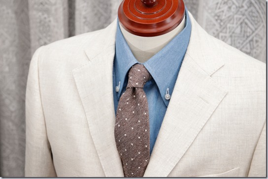 水色のデニムシャツにアイボリーのジャケットと薄茶のネクタイ